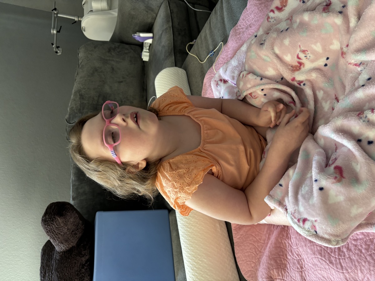 Sophia wearing pink glasses at home in 2024