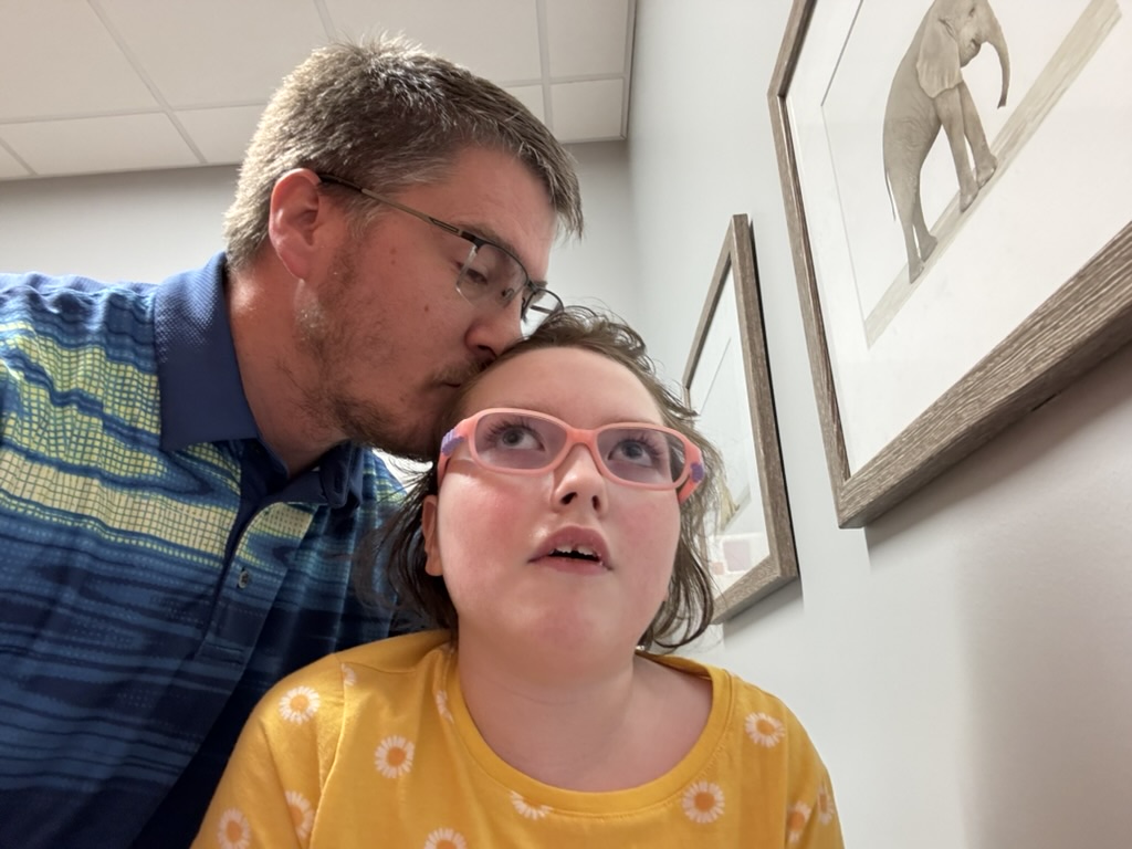 Dad kissing Sophia gently on the head
