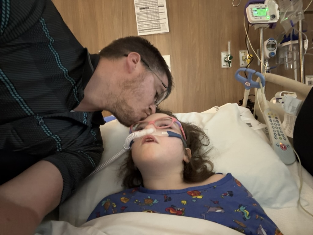 Dad comforting Sophia during a hospital stay