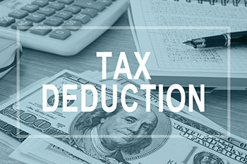 Tax deduction text over money, paperwork, and calculator